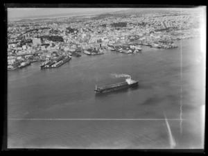 Auckland waterfront and Waitemata Harbour including barge used in the construction of Auckland Harbour Bridge extensions
