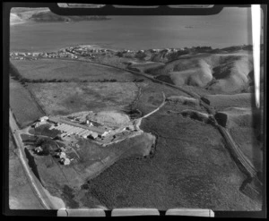 View south over Winstone Tile Factory with Taupo Swamp and State Highway 1 in foreground to the coastal settlement of Plimmerton beyond, North Wellington Region