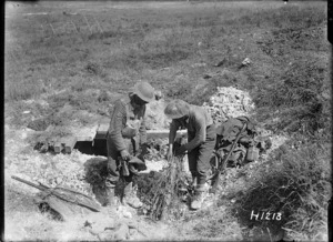 New Zealand soldiers camouflaging a gun during World War I, France