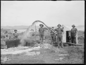 Men washing soil to locate kauri gum, Northland