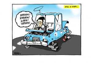 Simon Bridges driving the broken blue "Nats law & order policy' car as it sits on chocks