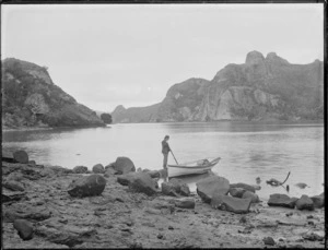 Man with row-boat, at the edge of Whangaroa Harbour, Northland region