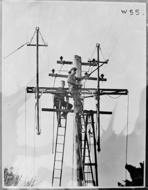Live line workers changing circuits on a transmission line pole