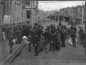 Men gathered in a street to look at Evening News war maps, Cathedral Square, Christchurch