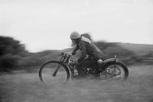 Willie O'Brien racing a motorcycle, Tuhikaramea grass track near Hamilton