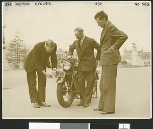 Introduction of learner plates for motor vehicles; shows the Minister of Transport, Robert Semple, on left, holding a plate to an Indian Scout 45 motorcycle, Wellington