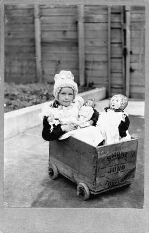 Dora Helyer in a box cart with dolls