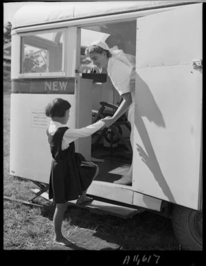 Dental nurse helping a Maori girl into a mobile dental clinic, Te Kaha, Bay of Plenty - Photograph taken by W Wilson