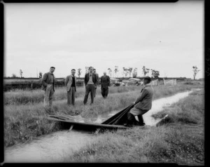 At the Winchmore Irrigation Research Station, Ashburton district, Canterbury, with Philip, the Duke of Edinburgh watching the removal of a canvas dam during the flooding of a border dyke irrigation scheme - Photograph taken by E P Christensen
