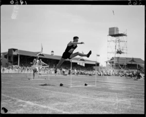 John 'Dutch' Holland straddling a hurdle, 1950 British Empire Games, Eden Park, Auckland