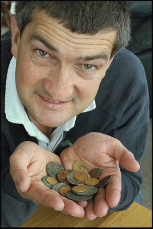 Bill Day holding coins recovered from the ocean floor near the Auckland Islands - Photograph taken by Phil Reid