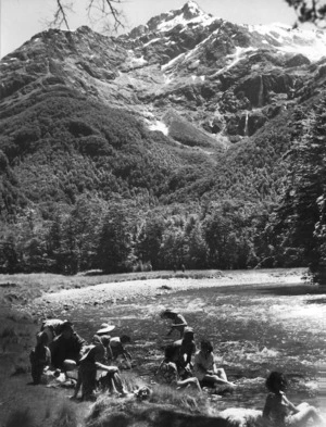 Members of a travel party alongside a river in the Route Burn Valley