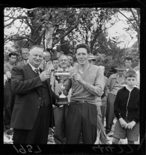 Upper Hutt timber man A Clouston presenting the Redwood Cup to axeman R Gallagher after the carnival chop at St Joseph's Orphanage, Upper Hutt