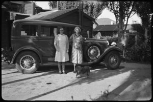 Nell and Helen Hare standing beside their Auburn car with Nellie the dog