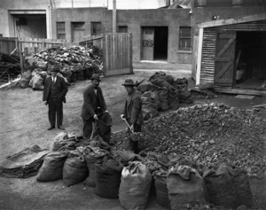 Relief workers shovelling coal into sacks, probably in Wellington