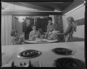 Family with cake in front of stove