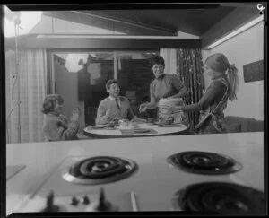 Family with cake in front of stove