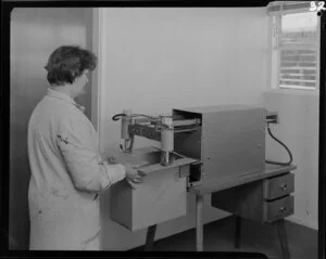 Women operating cardboard box glueing machine