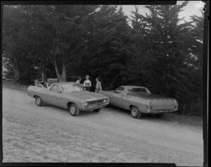 People talking next to two Ford Falcon utes