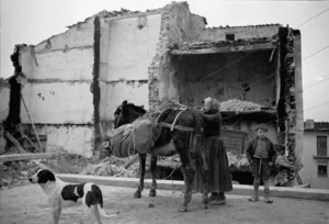 Woman, donkey and child, alongside ruins, Gessopalena, Italy