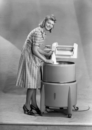 A model poses by a wringer washing machine