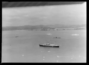 Royal Yacht Britannia and destroyer escort, with submarine, Bay of Islands