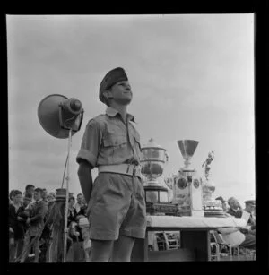 Boy in uniform beside trophy table, Royal New Zealand Aero Club pageant, Ardmore