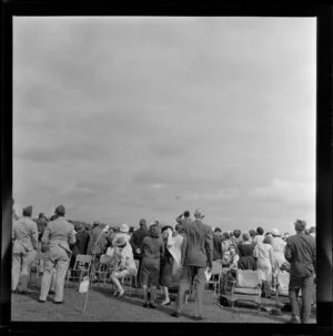 Spectators watching a parachutist at the Royal New Zealand Aero Club pageant, Ardmore