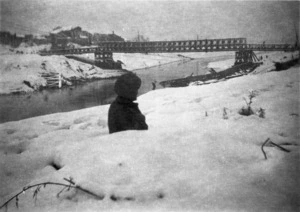 Gordon Spencer, fl 1945 : Corporal Randell of 21 Battalion, sitting in a German slitty in the snow, looking over the Lamone River at Faenza, Italy