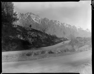 Car travelling on road near Queenstown, with The Remarkables in the background