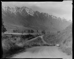 Car travelling on road near Queenstown, with The Remarkables in the background