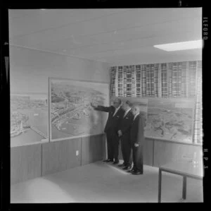 Unidentified men looking at exhibition of Whites Aviation photographs, Auckland Harbour Board