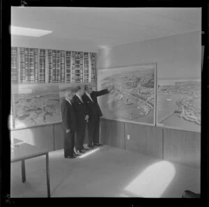 Unidentified men looking at exhibition of Whites Aviation photographs, Auckland Harbour Board