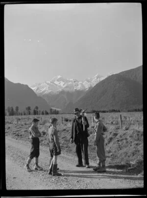Roadman Mr Moroney talking to four children at Fox Glacier, West Coast Region
