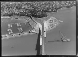 Construction of southern approaches to Auckland Harbour Bridge, with cranes erecting the "Nippon Clipons"