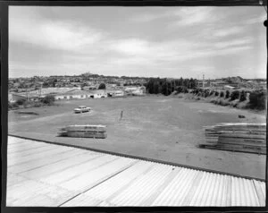 Poultrymen's Co-Operative Penrose site with a man surveying the vacant site and the suburb in the background, Auckland