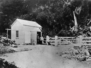 Otira toll gate, with W C Wells and his son Johnny standing in the doorway of the nearby hut
