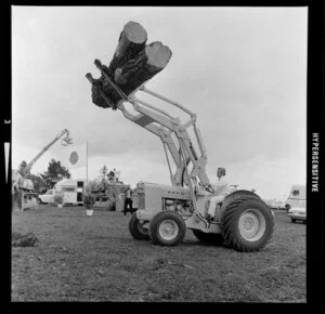 A man driving a Ford front loader for moving logs