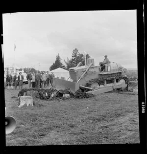 A demonstration of a Komatsu caterpillar tractor pushing tree stumps