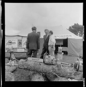 Two unidentified men speaking to Member of Parliament, Duncan McIntyre, at the Husqvarna display