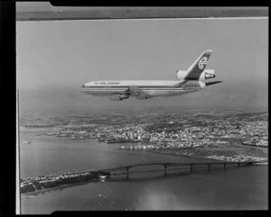Copy photograph of a DC10 aircraft flying over Auckland Harbour Bridge