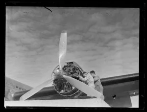Ground crew working on engine of Australian National Airways, clipper 'the Amana'
