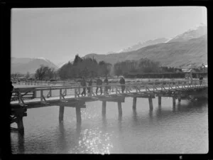Unidentified group of men crossing bridge, Lake Wakatipu, Queenstown