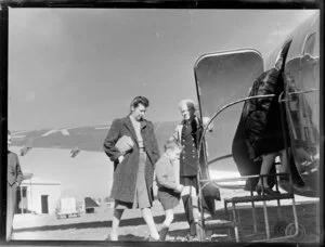 Unidentified woman and child boarding aircraft, New Zealand National Airways Corporation, Harewood Airport, Christchurch