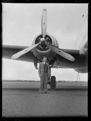 Mr A Jones, Pan American Airways, standing under the propellor of an aeroplane