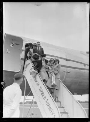 Stewardess helping girl with a broken leg off the aeroplane, Pan American Airways