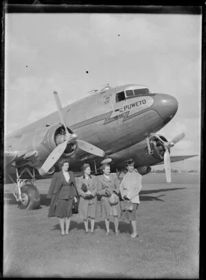 Four women standing in front of the Dakota aircraft Puweto, Milson Aerodrome, Palmerston North