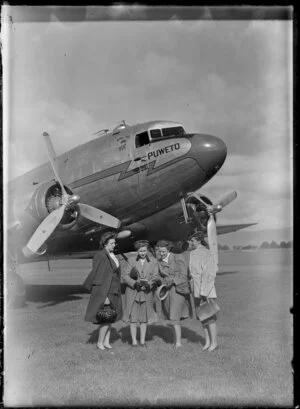 Four women standing in front of the Dakota Puweto, Milson Aerodrome, Palmerston North