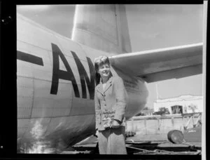 Miss Maile Morris standing by a flying boat
