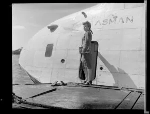 Miss Maile Morris, Miss New Zealand competitor, standing beside a flying boat
